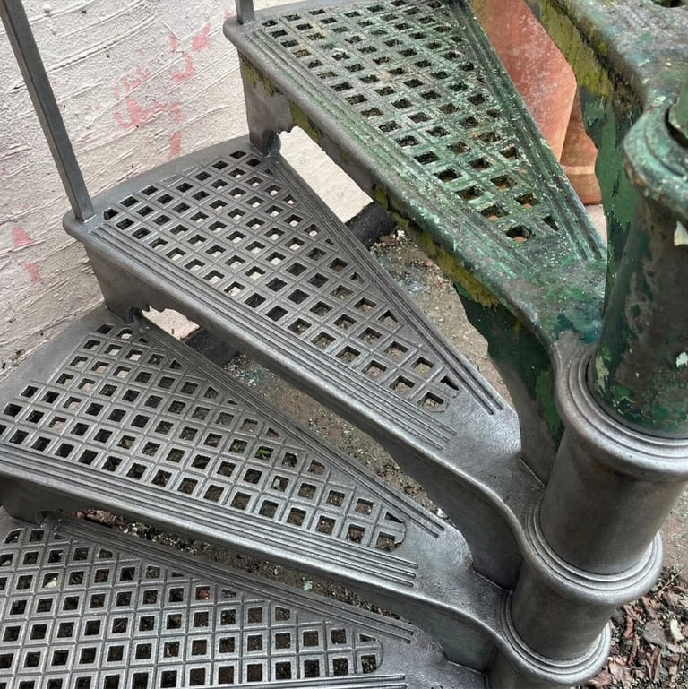 Stack of metal vehicle running boards with perforated grip surfaces and weathered patina