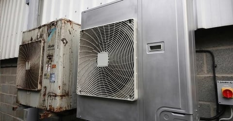 Row of outdoor HVAC air conditioning units mounted on building exterior wall